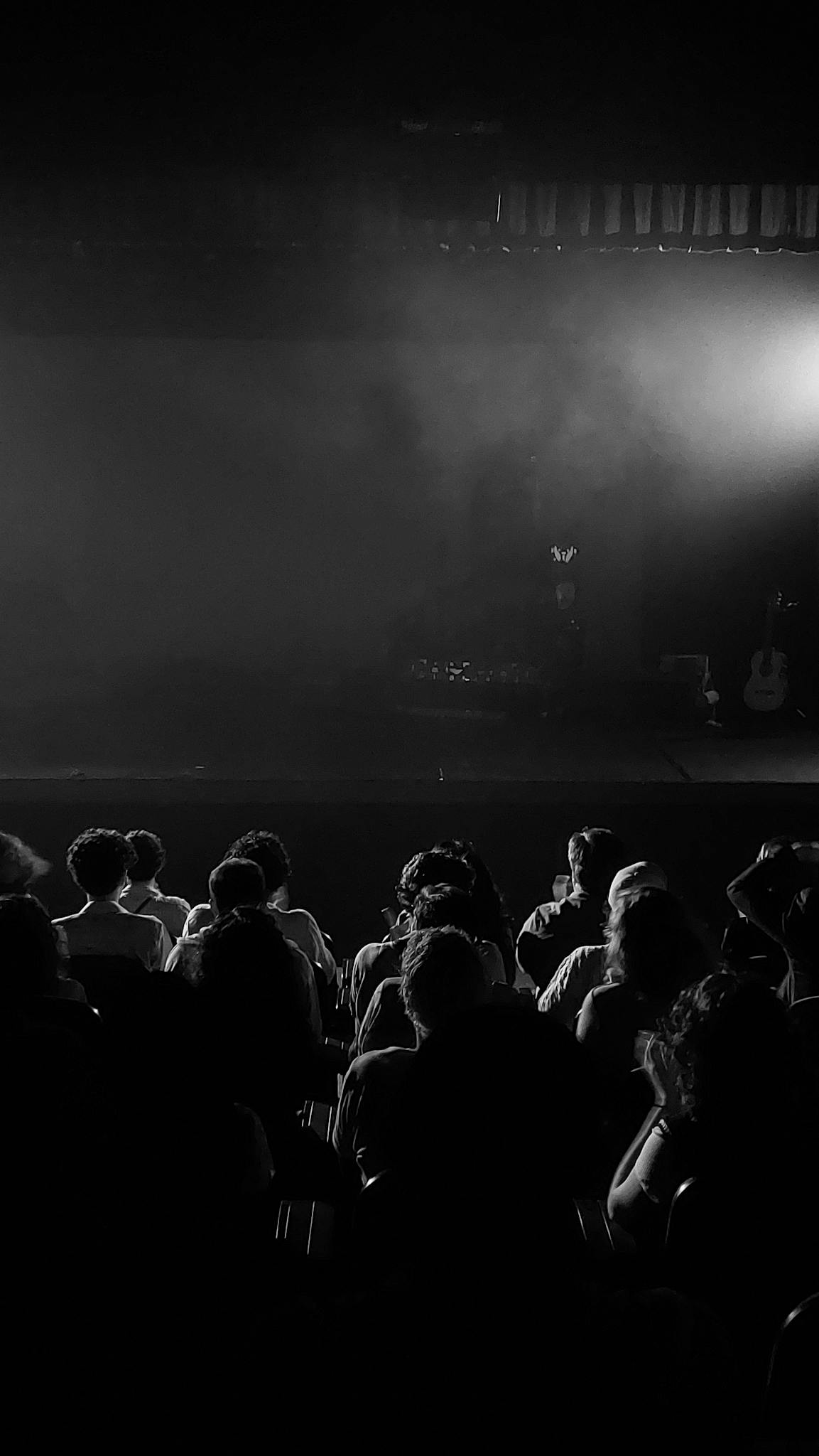 A theater audience immersed in a mysterious stage performance in Campina Grande, Brazil.